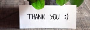 thank you note on a desk beside a plant. Housewarming, or thank-you gift? Both!